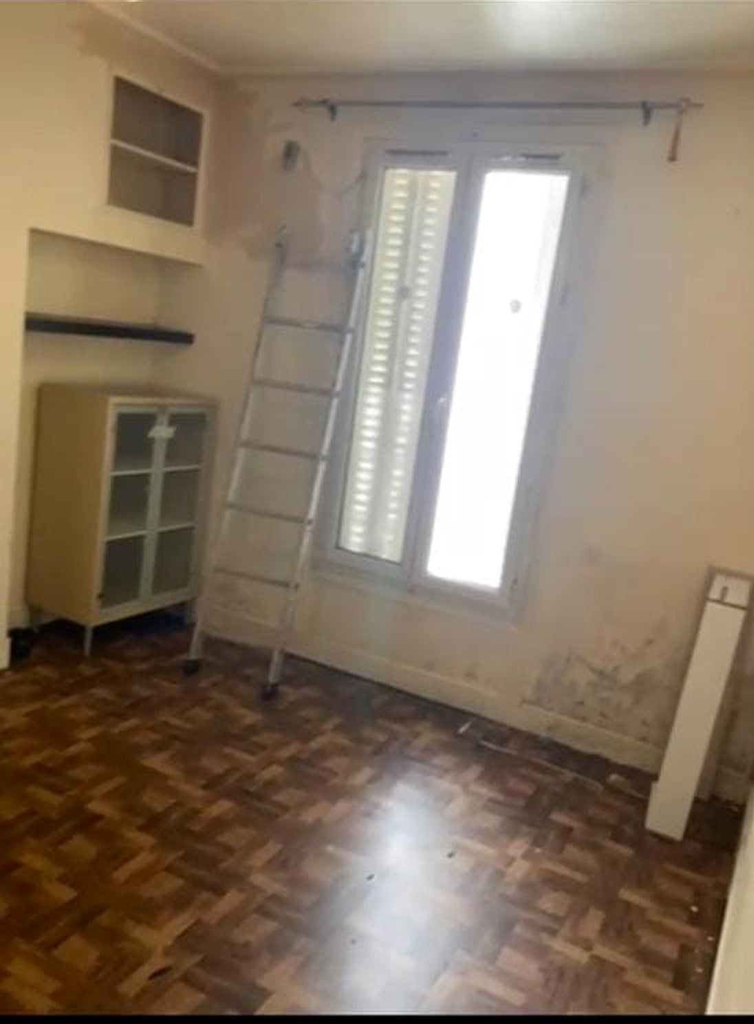 Chambre avant rénovation — murs abîmés et sol vétuste