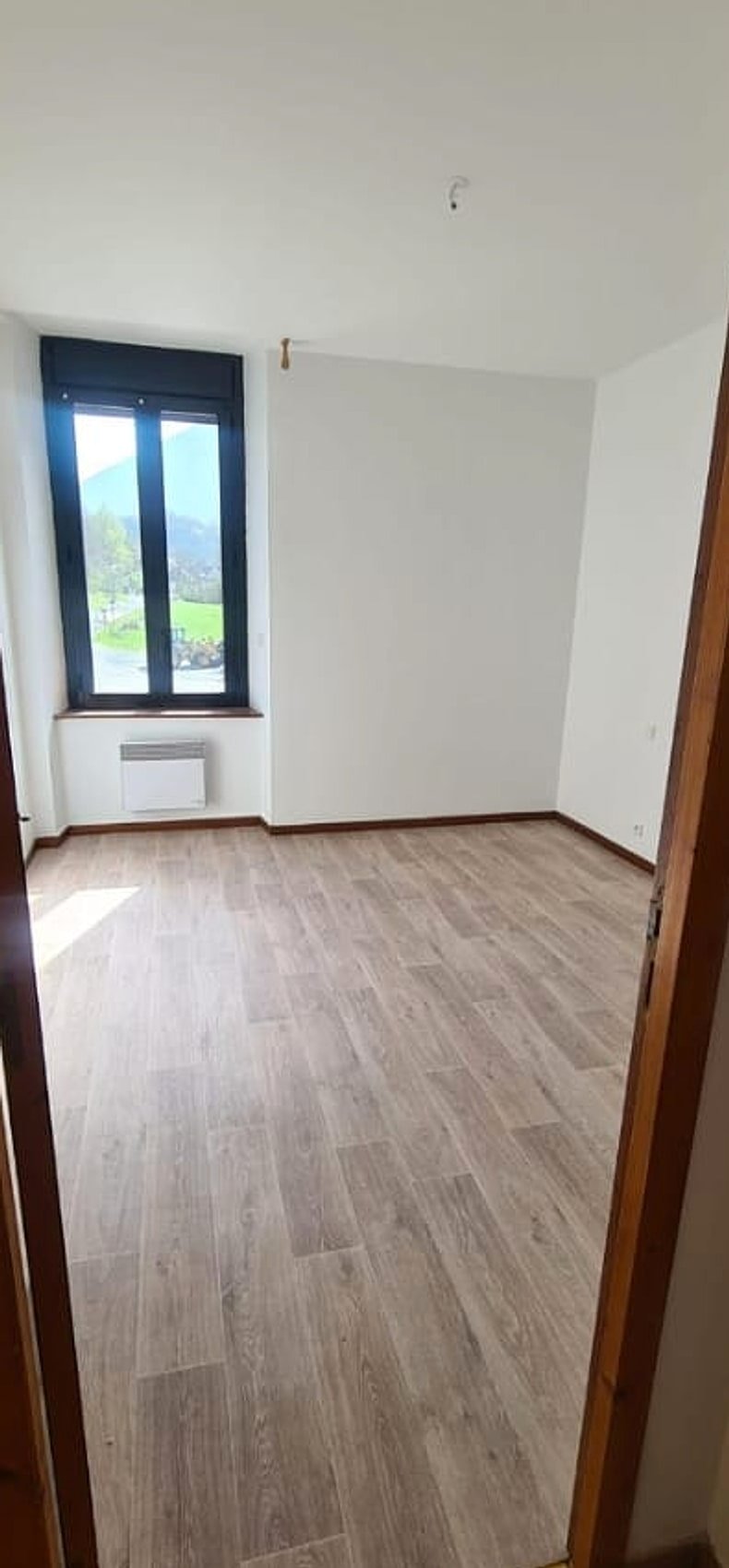 Séjour après rénovation — parquet moderne et murs repeints en blanc