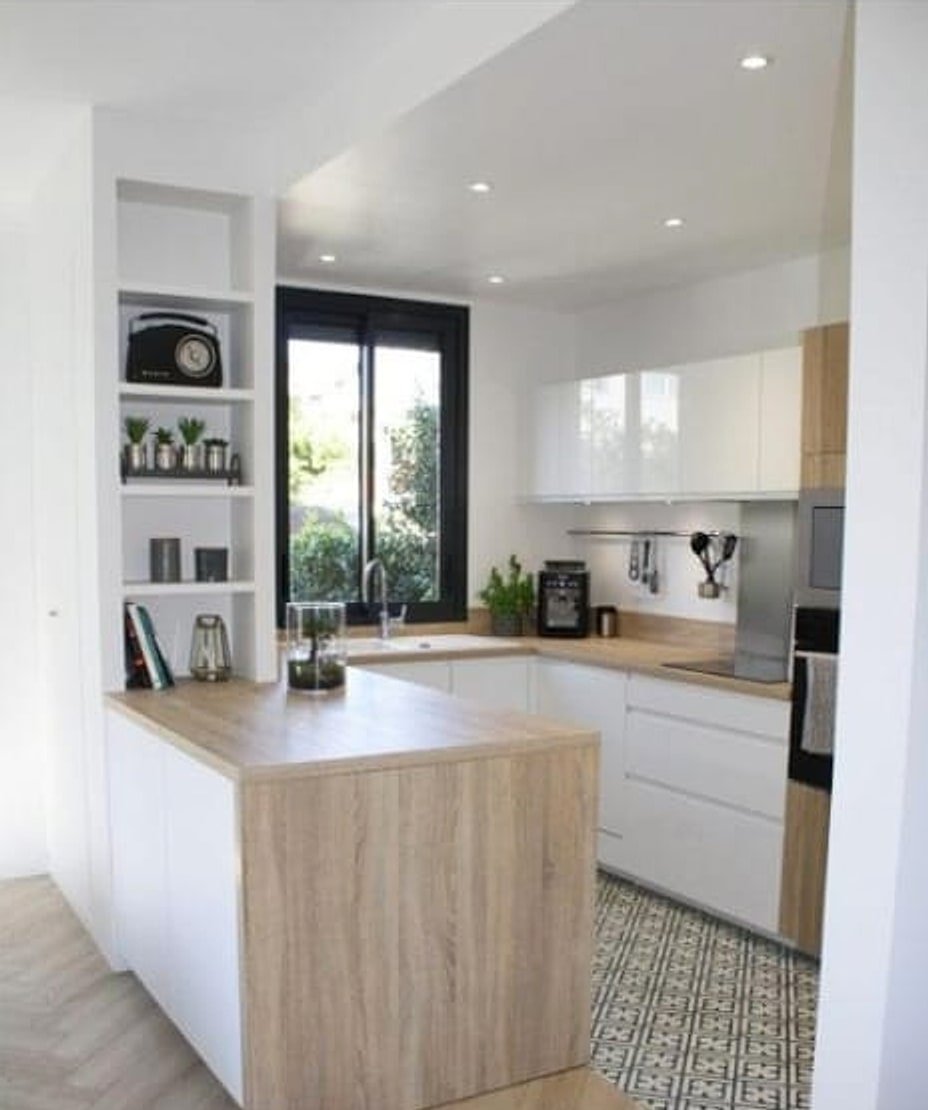 Cuisine après rénovation — meubles blancs, plan de travail bois, carreaux de ciment