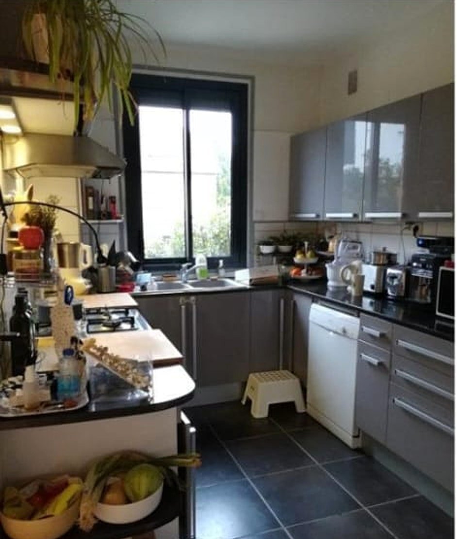 Cuisine avant rénovation — mobilier daté et carrelage sombre