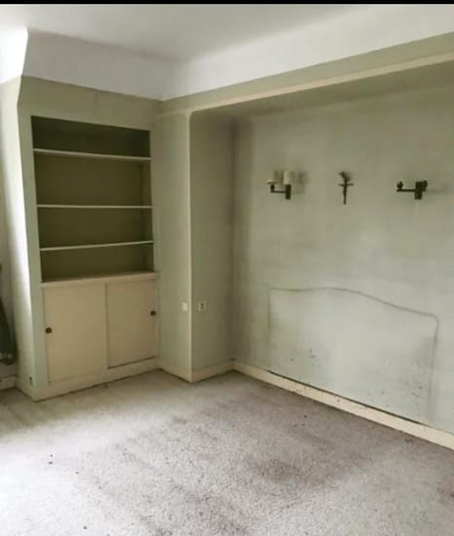 Chambre sous combles avant rénovation — moquette usée et murs défraîchis