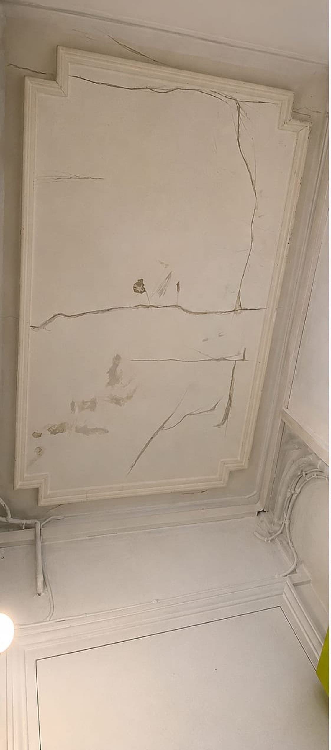 Moulures haussmanniennes avant restauration — plâtre fissuré et éclats